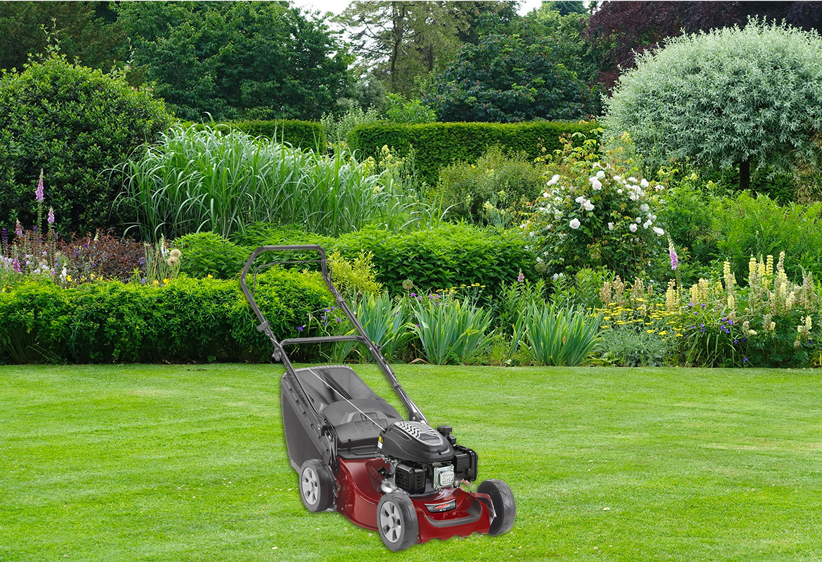 Η χλοοκοπτική μηχανή με φόντο έναν κήπο.